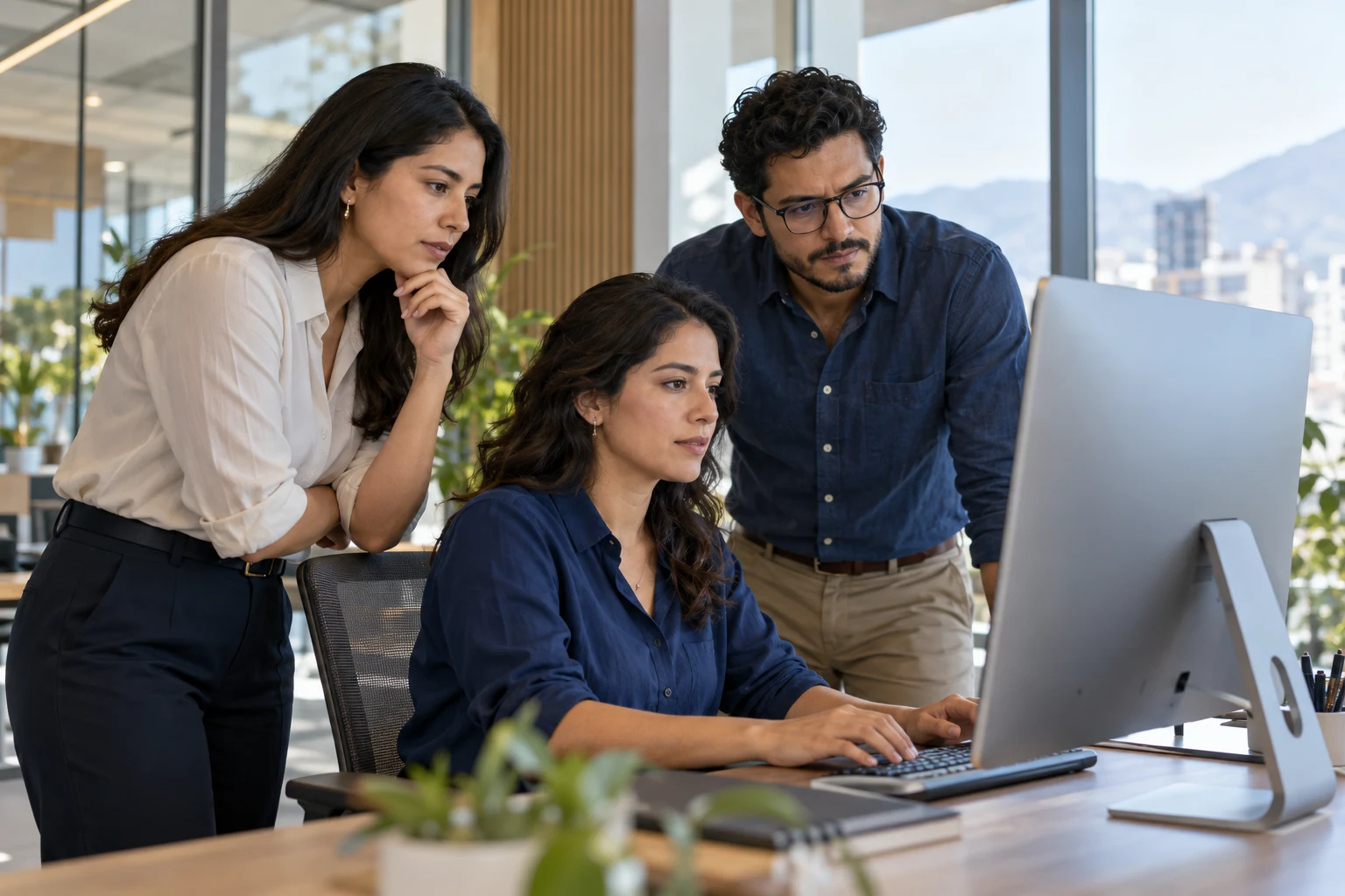 Software engineers reviewing a desktop application together in a modern office